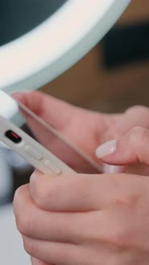 Woman's Hands Using a Mobile Phone With Ring Light