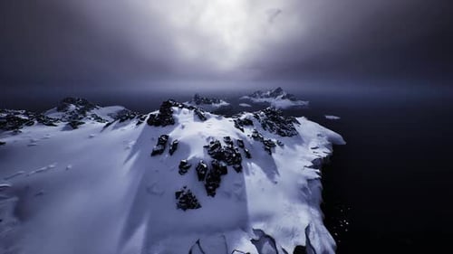 A névoa velada suaviza o horizonte distante enquanto formações escuras surgem da neve