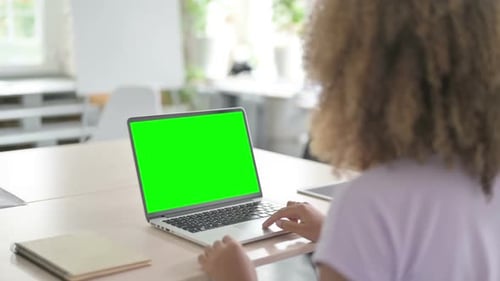 African Woman Using Laptop with Chroma Key Screen
