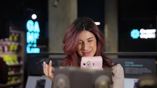 Positive Smiling Girl Chooses Digital Camera in Digital Store