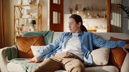 Exhausted Brunette Sitting Couch Looking Around Bored Face at Home Tired Man