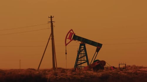 Pumping Petroleum Rig in Desert at Sunset Oil Industry Pump Jack Extracting Crude Oil From a Oil