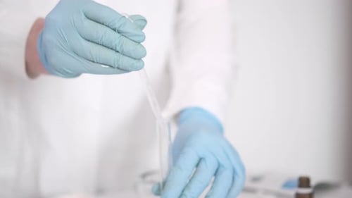 Scientist Using Pipette to Transfer Liquid