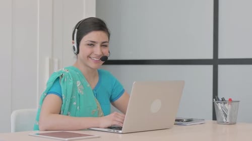 Young Indian Woman with Headset Smiling at Camera in Call Center