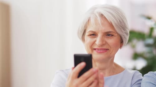 Senior and young adult women looking at phone