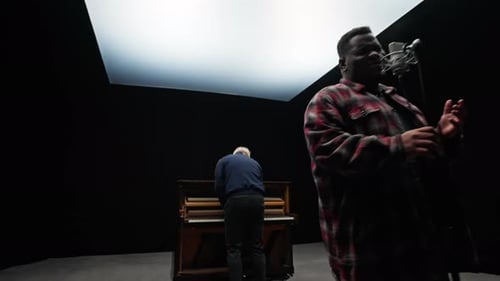 A Man Playing The Piano With A Singer In A Studio