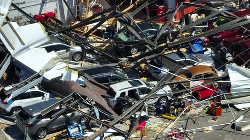 Hurricane Destroyed Industrial Building with Damaged Cars Under Ruins in Florida Natural Disaster