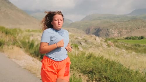 Woman Jogging on Rural Road with Mountain View