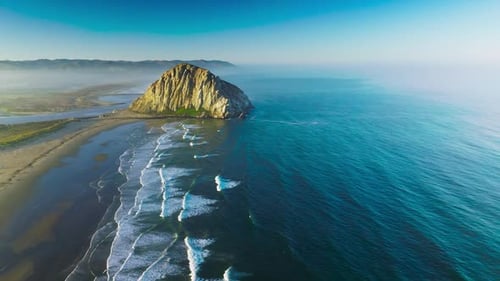 Splendid scenery of Pacific Ocean coastline with huge rock on the beach.