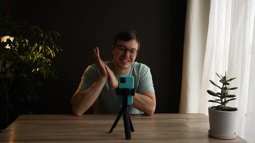 Young Man Talks to Phone on Tripod at Desk