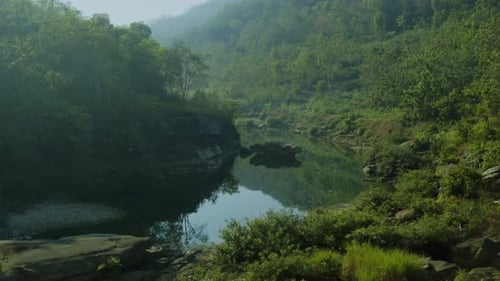 Drohnenflug über einem gewundenen Fluss, umgeben von tropischem Dschungel