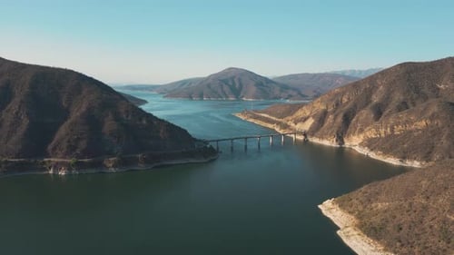 Aerial drone flying over a lake, water dam, with mountains at sunrise. Beautifull dreamy landscape v