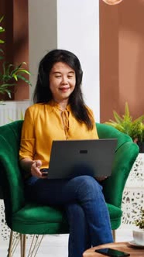 Vertical Video Asian Tourist Ordering Coffee Cup While She Works on Laptop