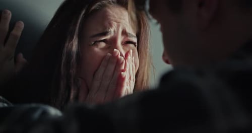 Close Up Over the Shoulder a Brunette Girl Cries While Her Boyfriend Aggressively Swears at Her