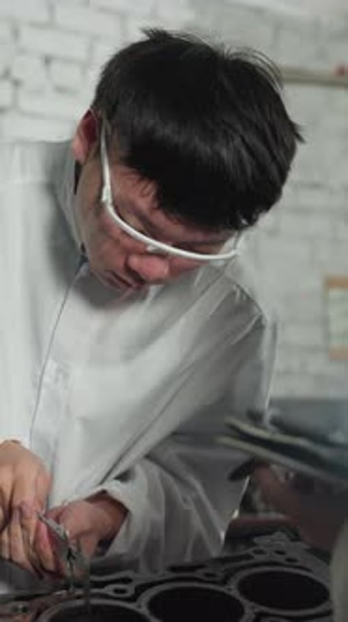 Mechanical Engineer Measuring Engine Thickness in Industrial Workshop