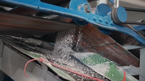 Industrial Machine Discharging Shredded Material onto Conveyor Belt