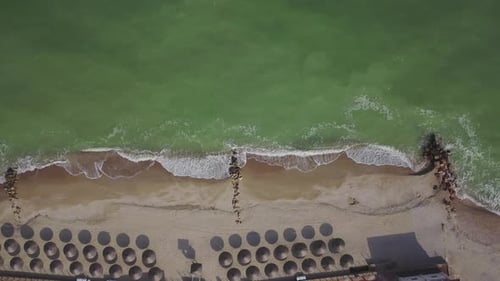 Aerial View of Straw Umbrellas on the Beach Ocean Waves Washing Sandy Shore Tranquil Coast Line of a