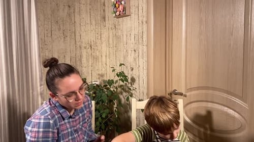 Woman Teaches Boy Guitar at Home