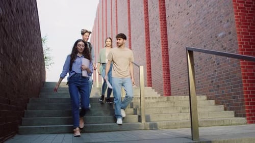 Three caucasian students walking down the stairs at university campus. Shot with RED helium camera i