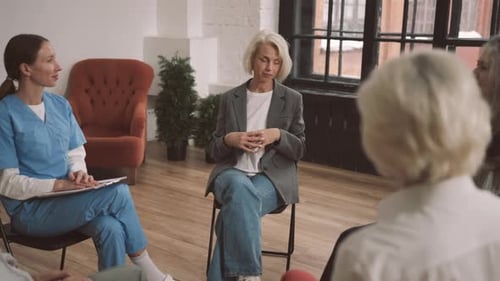Mature Blonde Woman in Group Meeting in Psychological Clinic Mental Health Consultation with