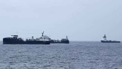Telescopic shot of three fishing boats fishing together near land. Shot near Stornoway on the Isle o
