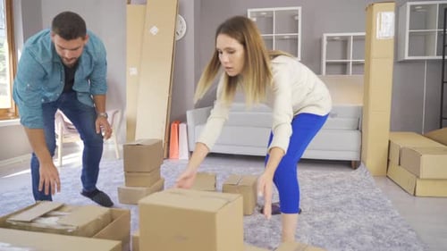 Couple Unpacking Boxes Together in New Home