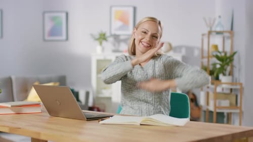 Woman sitting at desk gestures enthusiastically with hands