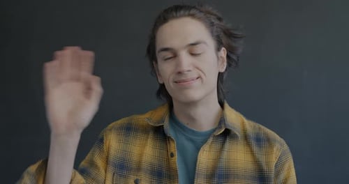 Young Adult Man Waving Hello With a Smile