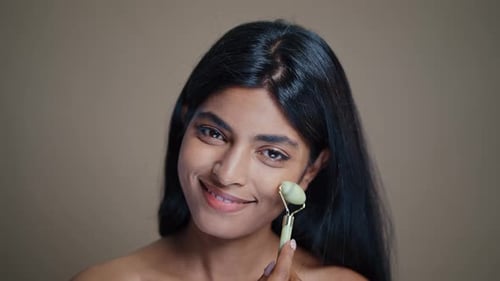 Woman Using Jade Roller on Face Close-Up