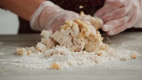 Frau benutzt Nudelmaschine, um frischen Nudelteig in der Küche zuzubereiten und kocht in einem italienischen Restaurant