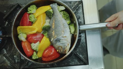 Sea Bream Cooks in a Skillet with Vegetables