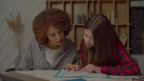 Multiethnic Teenager Girl and Black Mom with Textbook Studying Foreign Language