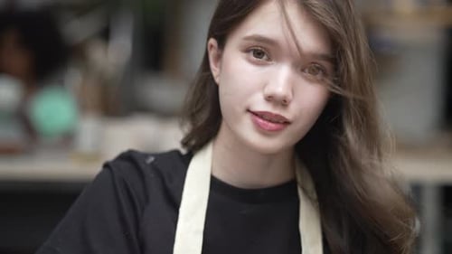 Young women is making earthenware at workshop.