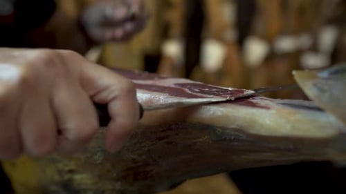 Expert Slices Cured Ham with Precision and Care