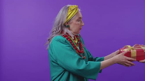 An Elderly Woman in Vibrant Colorful Attire Posing Beautifully Against a Purple Background