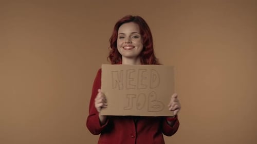 Medium Isolated Video of a Joyful and Active Young Woman Holding a Piece of Cardboard That Says