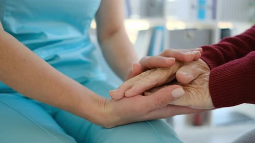 Caring Hands of Caregiver with Elderly Patient