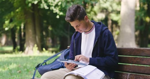 Student Using Tablet While Studying in Park
