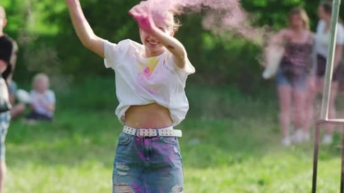 Girl Throwing Up In The Air Colorful Paint At Holi Celebration