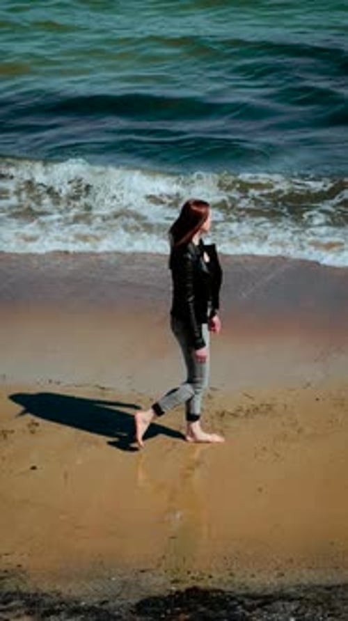 Woman Walking Near Sea Edge on Sandy Beach Vertical Orientation Female Strolling Barefoot Along