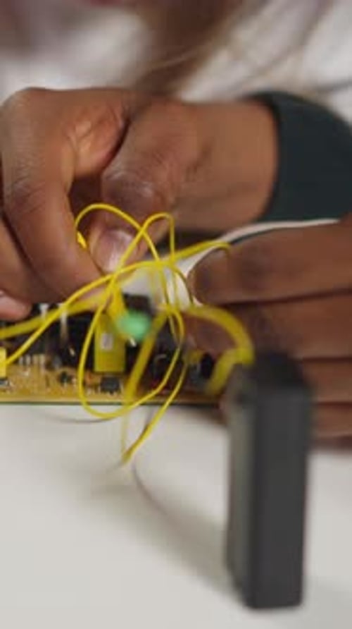 Der Techniker bringt dem Mädchen bei, Drähte mit Sonden an den Chip anzuschließen