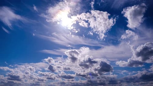 Timelapse of Fluffy Clouds Moving Under the Sun in the Blue Sky