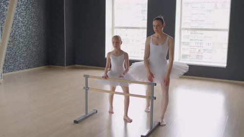 Trainer Teaching Little Ballet Dancer How to Stand in Pose near Barre
