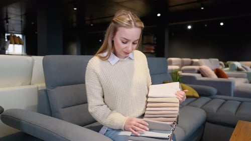 Woman Choosing Fabric Swatches in Furniture Showroom