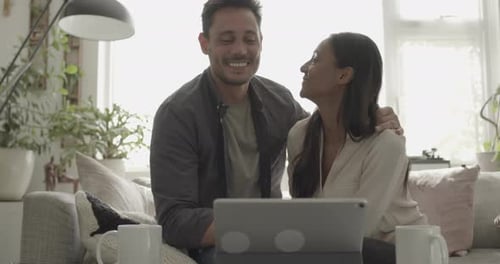 Couple Using Tablet Together on Couch at Home
