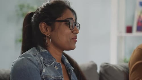Indian Woman with Ponytail Smiles Watching Comedy Movie