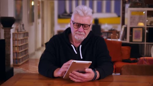 Man Using Tablet at Wooden Table Indoors