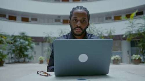 Young AfricanAmerican Businessman Working with a Laptop on the Street