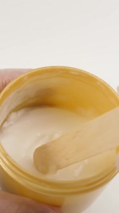 White Beauty Cream Scooped from Gold Jar