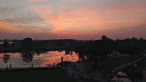 Dramatisch Sonnenuntergang über einem ruhigen See, der warme Farben widerspiegelt
